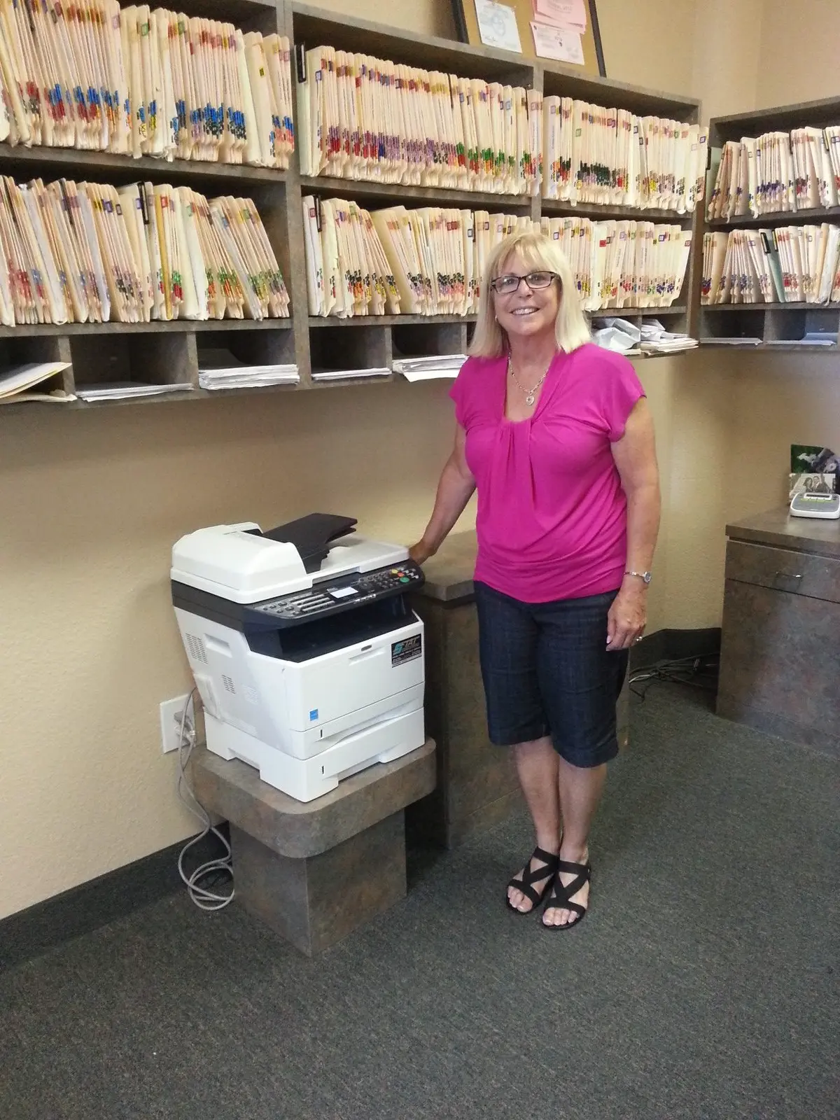 Business printer positioned near a records workflow in a professional office